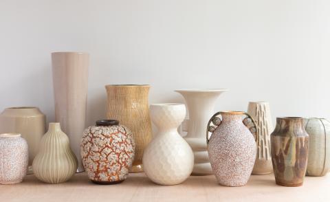Photo of 12 earth-colored light ceramic vases of different designs.